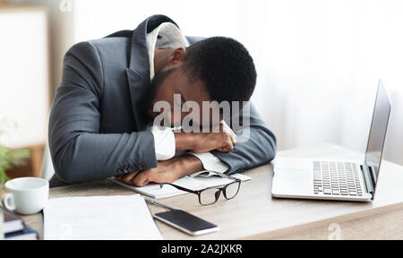 Müde afrikanische amerikanische Geschäftsmann in ein Nickerchen am Arbeitsplatz Stockfoto