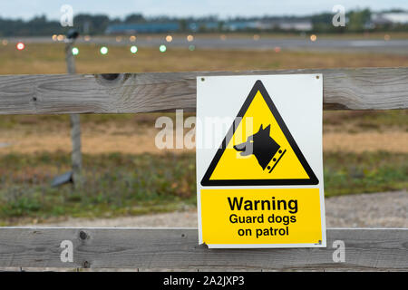 Warnung Wachhunde auf Patrouille Schild an der Umzäunung in Blackbushe Airport, UK Stockfoto