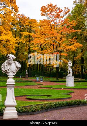 St. Petersburg, Russland, 3. Oktober 2019. Herbst Farben der Bäume im Sommer Garten mit klassischen Marmorstatuen Stockfoto