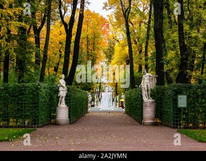 St. Petersburg, Russland, 3. Oktober 2019. Farben des Herbstes und Bäume im Herbst auf einem Pfad in den Sommer Garten mit einem Brunnen und klassischen Marmorstatuen Stockfoto