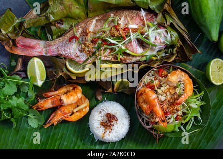 Red Snapper im Bananenblatt, Papaya Salat und Reis Stockfoto