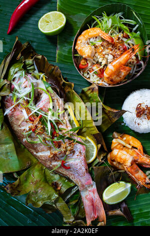 Red Snapper im Bananenblatt, Papaya Salat und Reis Stockfoto