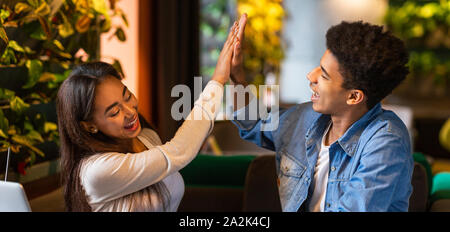 Fröhlicher Kerl und Mädchen gegenseitig hoch fünf Stockfoto