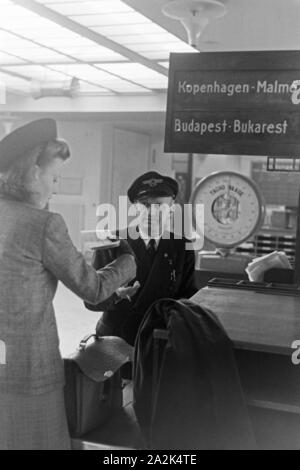 Eine Passagierin mit einem Zollbeamten auf dem Flugplatz Tempelhof in Berlin, Deutschland, 1930er Jahre. Ein weiblicher Passagier mit einem Zollbeamten am Flughafen Berlin Tempelhof, Deutschland 1930. Stockfoto