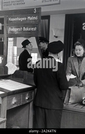 Eine Passagierin mit einem Zollbeamten auf dem Flugplatz Tempelhof in Berlin, Deutschland, 1930er Jahre. Ein weiblicher Passagier mit einem Zollbeamten am Flughafen Berlin Tempelhof, Deutschland 1930. Stockfoto