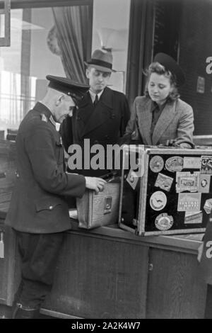 Eine Passagierin mit einem Zollbeamten auf dem Flugplatz Tempelhof in Berlin, Deutschland, 1930er Jahre. Ein weiblicher Passagier mit einem Zollbeamten am Flughafen Berlin Tempelhof, Deutschland 1930. Stockfoto