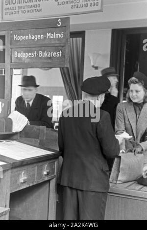 Eine Passagierin mit einem Zollbeamten auf dem Flugplatz Tempelhof in Berlin, Deutschland, 1930er Jahre. Ein weiblicher Passagier mit einem Zollbeamten am Flughafen Berlin Tempelhof, Deutschland 1930. Stockfoto