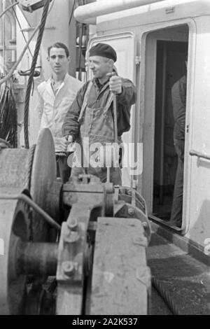 Männer der Besatzung des Fabrikschiffes "Jan Wellem" der deutschen Walfangflotte an der Seilwinde, 1930er Jahre. Besatzungsmitglieder der Fabrik Schiff "Jan Wellem" des Deutschen walfangflotte am Drahtseil, 1930er Jahre. Stockfoto