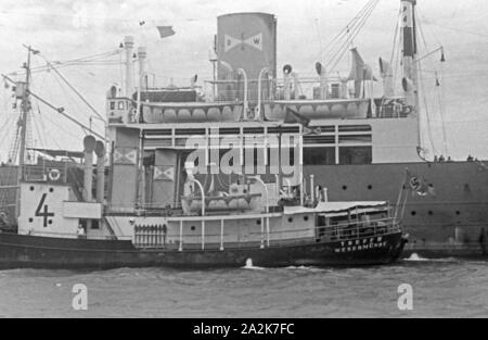 Fangboot' Treff IV" der deutschen Walfangflotte beim Mutterschiff "Jan Wellem", 1930er Jahre. Walfang Boot "Treff IV" der Deutschen Walfangflotte mit seiner Mutter Schiff "Jan Wellem", 1930er Jahre. Stockfoto