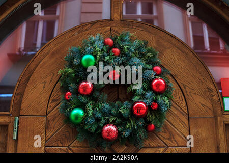 Traditionelle Weihnachten Kranz aus Fichte Äste hängen hölzerne Tür Stockfoto