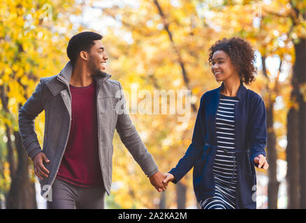 Schwarz Paar in der Hand beim Gehen im Herbst Wald Stockfoto