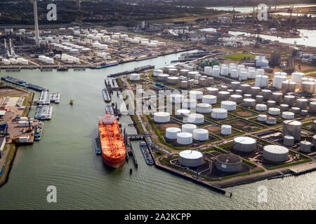 Luftaufnahme von Eine große orange Öltanker in einem Öllager silo Terminal in einem industriellen Hafen vertäut. Stockfoto