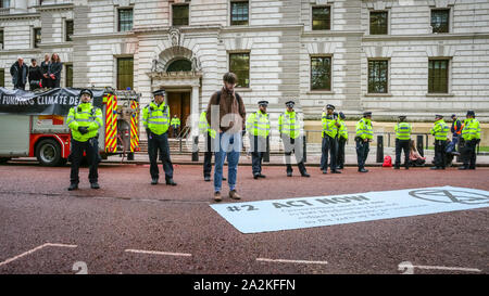 HM Treasury, Westminster, London, Großbritannien. 02 Okt, 2019. Aussterben Rebellion Demonstranten haben die Treasury Gebäudes in Westminster mit Fake Blood aus dem Schlauch eines stillgelegten Fire Engine gesprüht und sind stark unter Anwesenheit der Polizei festgenommen. Credit: Imageplotter/Alamy leben Nachrichten Stockfoto