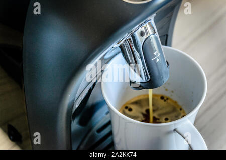 Espresso Kaffeemaschine Maschine und heraus fließenden Espresso in ein weißes Porzellan Schale Stockfoto