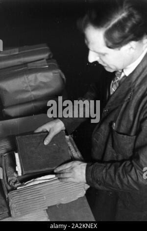 Fuer Angestellte beim täglichen Umgang mit Sammlungen und Bänden für den internationalen Leihverkehr in der Staatsbibliothek zu Berlin Unter den Linden, Deutschland 1930er Jahre. Mitarbeiterinnen und Mitarbeiter in ihrem täglichen Geschäft mit Sammlungen und Objekte für internationale Bibliothek Ausleihe bei der Deutschen Staatsbibliothe Bibliothek in Berlin Unter den Linden, Deutschland 1930. Stockfoto