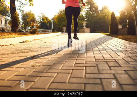 Ein Mann in Sportkleidung läuft auf der Straße in den Morgen. Stockfoto