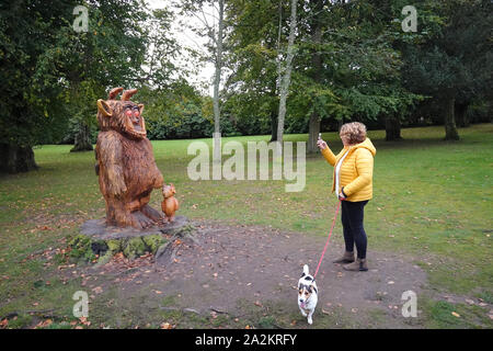 Eine Frau nimmt ein Foto einer Gruffalo-Statue im Hazlehead Park in Aberdeen auf Stockfoto