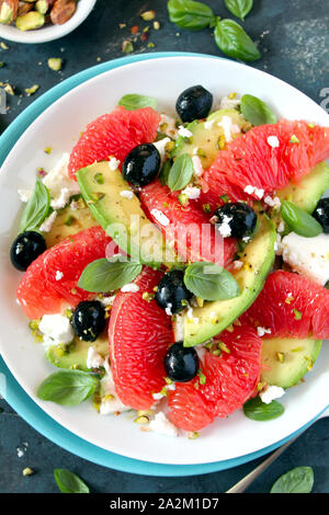 Avocado-salat mit grapefruits, FETA-Käse, schwarzen Oliven und Pistazien. Ansicht von oben mit der Kopie. Gesundes Essen. Stockfoto