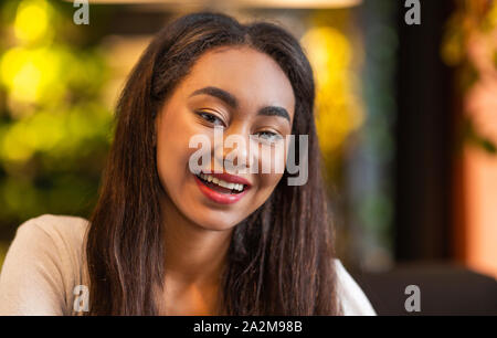 Schöne junge Mädchen lächelnd an Kamera, Kühlen im Cafe Stockfoto