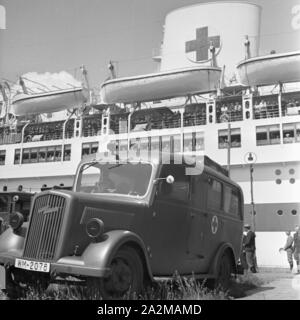 Original-Bildunterschrift: Sanitätswagen bringen sterben Verwunden / der Entladung von der "Wilhelm Gustloff" im Sterben Standorte bzw. Lazarette, Deutschland 1940er Jahre. Ambulanzfahrzeuge, die verwundeten Soldaten in die Kasernen oder militärische Krankenhäuser, Deutschland 1940. Stockfoto