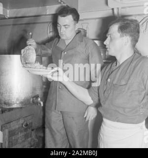 Original-Bildunterschrift: Dienst des Matrosen: essenfassen in der Kombüse ein Bord eines Torpedobootes, Deutschland 1940er Jahre. Sailor's Pflicht: Chow Zeit in der Küche auf ein Torpedoboot, Deutschland 1940. Stockfoto