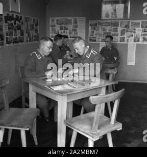 Original-Bildunterschrift: Freizeit in der Kaserne - damespielen im Gemeinschaftsraum, Deutschland 1940er Jahre. Freie Zeit in der Kaserne - Spielen der Entwürfe im Aufenthaltsraum, Deutschland 1940. Stockfoto