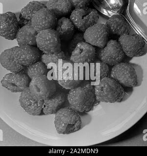 Nahaufnahme eines Erzähler mit Himbeeren, Deutschland 1930er Jahre. Detailansicht der Platte mit Himbeeren, Deutschland 1930. Stockfoto