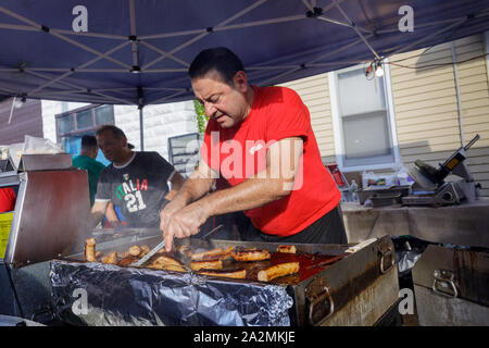 Italienischen Festival, Schenectady, New York: Mann kochen Wurst auf dem Grill. Stockfoto