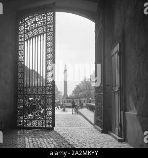 Blick durch das schmiedeeiserne Tor in das Stadtleben in Darmstadt, Deutschland 1930er Jahre. Blick durch ein schmiedeeisernes Tor zur Stadt leben in Darmstadt, Deutschland 1930. Stockfoto