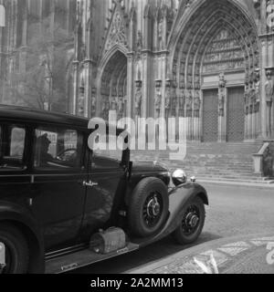 Pullman Limousine von Mercedes Benz vor dem Portal am Hohen Dom zu Köln, Deutschland 1930er Jahre. Pullman cab vor dem Haupteingang der Kathedrale in Köln, Deutschland 1930. Stockfoto