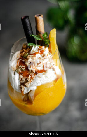 Bio Mango und Passionsfrucht tropische Eisbecher in Wein Glas Stockfoto