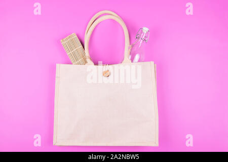 Mock up Baumwolltasche mit Glas und Bambus Serviette auf rosa Hintergrund. Eco minimalistischen Stil. Null Abfall Konzept, Platz für Text Stockfoto