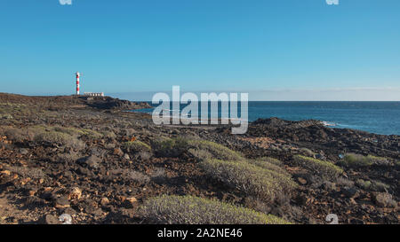 Trockene Landschaft von Malpais de la Rasca, einem Naturpark in der Nähe von Palm-Mar Stadt, mit Blick auf den Leuchtturm oder Faro Punta de Rasca, Teneriffa Stockfoto