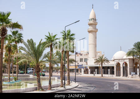 Aqaba, Jordanien - 19. Mai 2018: Stadtbild von Aqaba. Menschen gehen in der Nähe von Dawood Moschee am sonnigen Sommertag Stockfoto