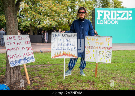 London, Großbritannien. 3. Okt 2019. Ein hochschullehrer Proteste über die Umweltauswirkungen von Fries - Frieze London, eine jährliche Kunstmesse im Regents Park. Es vereint mehr als 160 der weltweit führenden zeitgenössischen Galerien, mit speziellen kuratiert Abschnitte: Fokus, präsentiert neue Talente; Leben, eine Plattform für Performance Kunst; und Neu für 2019, gewebt, die Textilien erforscht, Weben und das Erbe des Kolonialismus. Es bleibt geöffnet bis 6. Oktober 2019. Stockfoto