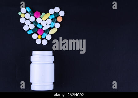 Verschiedene pharmazeutische Medizin Pillen, Tabletten und Kapseln und Flasche auf schwarzem Hintergrund. Kopieren Sie Platz für Text. Stockfoto