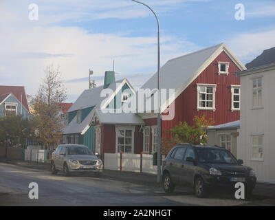 Die kleine Stadt Isafjordur verfügt über hell eingerichtete Gebäude im Gegensatz zu den vulkanischen, bergige Landschaft der Region Westfjorde Islands farbige Stockfoto