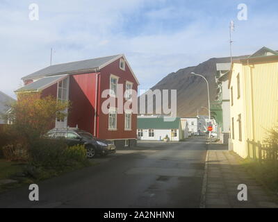 Die kleine Stadt Isafjordur verfügt über hell eingerichtete Gebäude im Gegensatz zu den vulkanischen, bergige Landschaft der Region Westfjorde Islands farbige Stockfoto