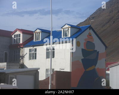 Die kleine Stadt Isafjordur verfügt über hell eingerichtete Gebäude im Gegensatz zu den vulkanischen, bergige Landschaft der Region Westfjorde Islands farbige Stockfoto