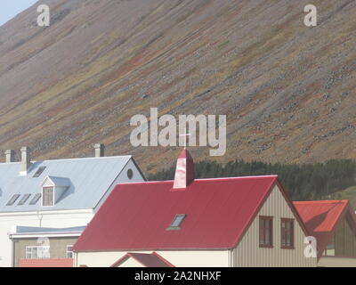 Die kleine Stadt Isafjordur verfügt über hell eingerichtete Gebäude im Gegensatz zu den vulkanischen, bergige Landschaft der Region Westfjorde Islands farbige Stockfoto