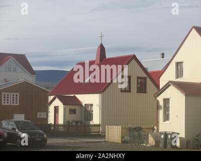 Die kleine Stadt Isafjordur verfügt über hell eingerichtete Gebäude im Gegensatz zu den vulkanischen, bergige Landschaft der Region Westfjorde Islands farbige Stockfoto