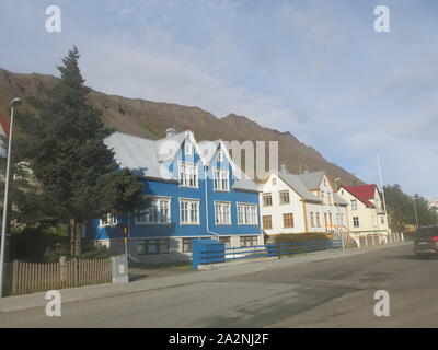 Die kleine Stadt Isafjordur verfügt über hell eingerichtete Gebäude im Gegensatz zu den vulkanischen, bergige Landschaft der Region Westfjorde Islands farbige Stockfoto