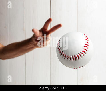 Baseball Pitcher, Nahaufnahme der Hand auf weißem Holz- Hintergrund zu werfen. Stockfoto