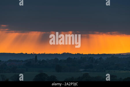 Ein heavy rain Cloud dramatisch ausgeleuchteten durch die untergehende Sonne in Warwickshire, England. Stockfoto