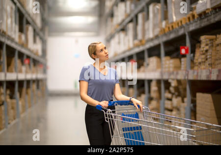 Fröhliche Frau Kunde, bis beim Druck Warenkorb in Hardware speichern Stockfoto
