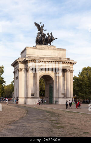 Touristen zu Fuß durch Wellington Arch, berühmte Denkmal in Central London, ist durch den Hyde Park. Stockfoto