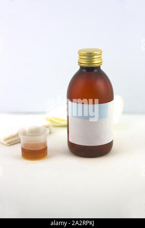 Eine Flasche Sirup Gesundheit Neben einigen Geweben auf weißem Hintergrund zu verbessern. Stockfoto
