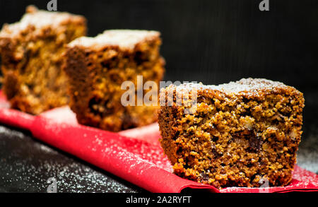Hausgemachte Torte Schichten auf einem schwarzen Hintergrund mit Schokolade, italienische amaretti Plätzchen, Nüsse und Yoghurt Stockfoto