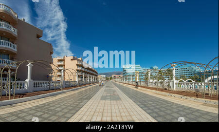 Breite Straße zu Fuß in der touristischen Ortschaft Playa de las Americas. Super wide angle Panoramablick. Klar, sonnigen Tag mit sehr wenigen Schönen weißen Wolken Stockfoto