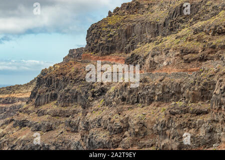 Luftaufnahme des schmalen Schotterpiste entlang den hohen Klippen, die zu Punta Llana, wo ist die Ermita de Nuestra Señora de Guadalupe. La Gomera, Kanarische Inseln Stockfoto